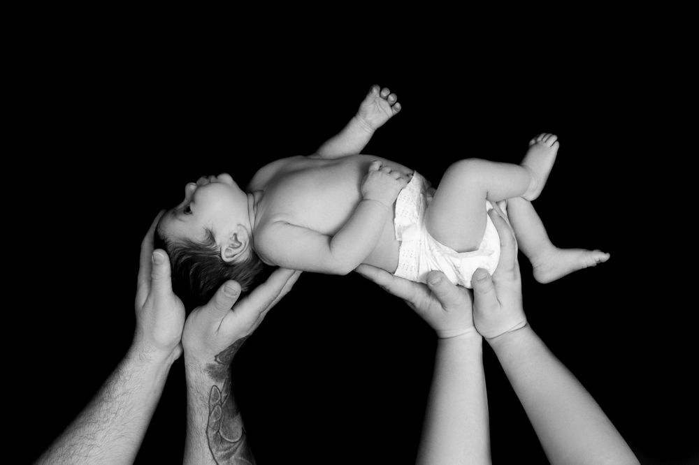 Black and white newborn photography sequence showing delicate positioning of a sleeping baby.