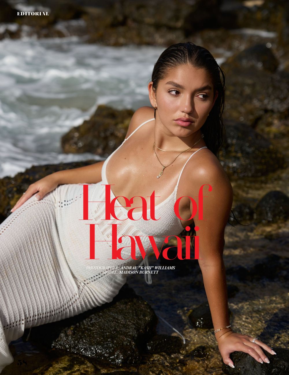 Model in white knit dress reclining on beach rocks with ocean waves in the background, golden hour lighting on her skin.