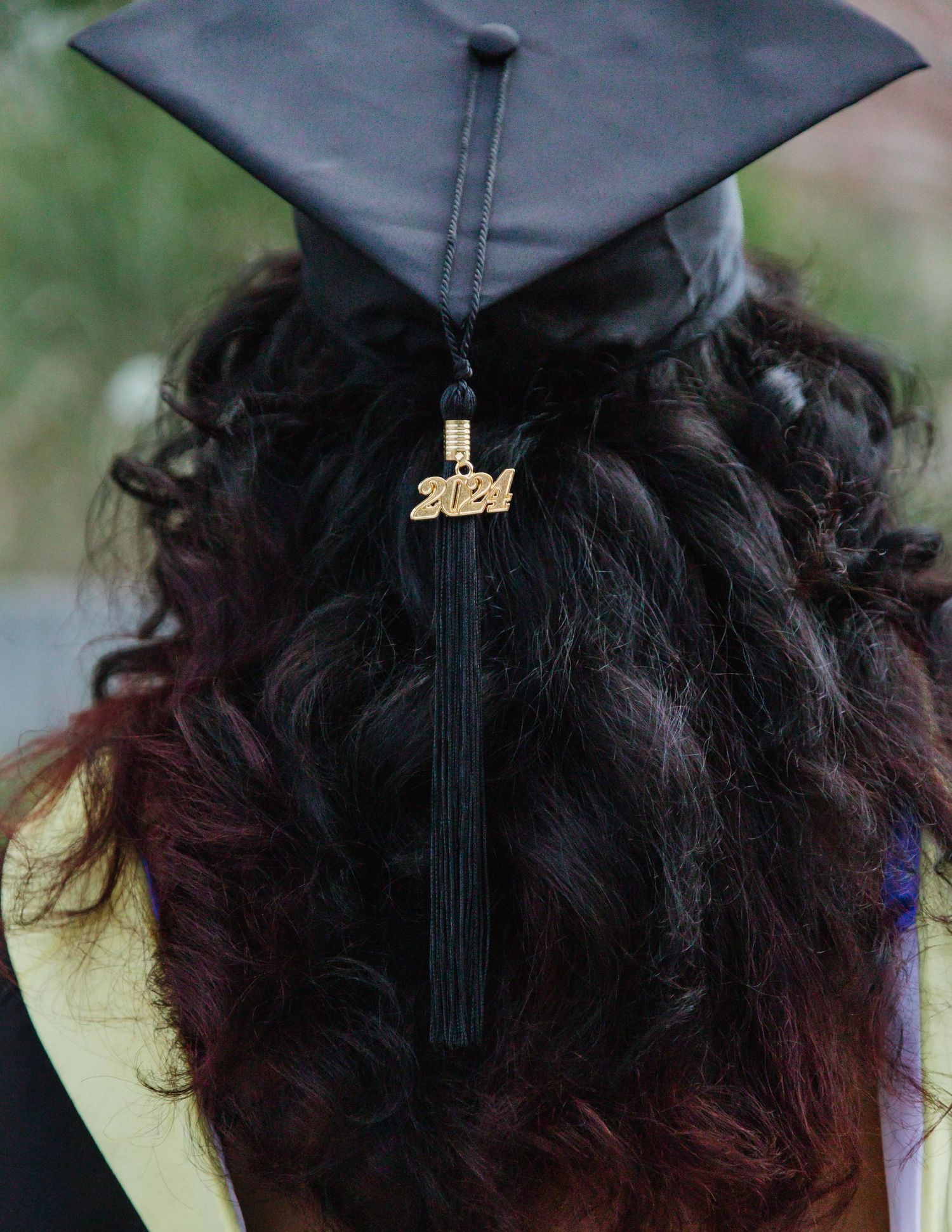 Close-up of a graduation cap with 2024 tassel against a blurred background.