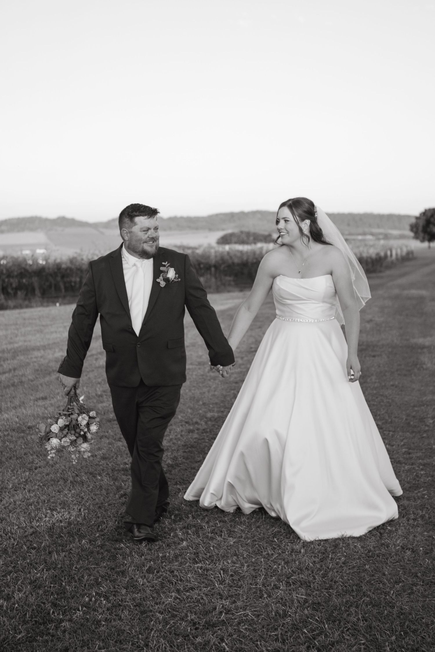 Bride and Groom walking holding hands at Two Rivers Denman Wedding