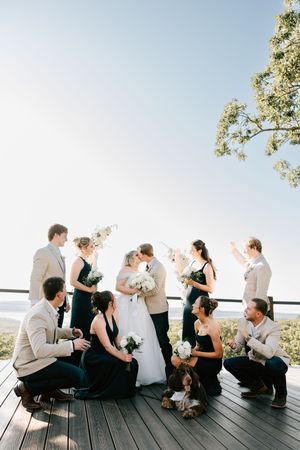 A wedding party poses with the bride and groom on the deck at 1684 Wedding Venue in Cookson, Oklahoma.