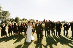 A biracial couple pose with their bridal party for their bridal party wedding portraits on their wedding day in Broken Arrow, Oklahoma.