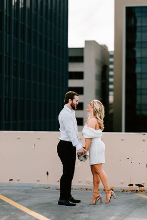A couple pose for their engagement session on the roof of a car garage in Oklahoma City, Oklahoma.