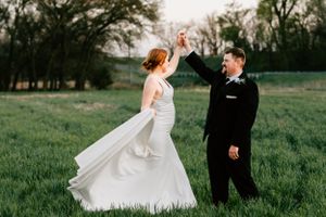 A bride and groom pose during their wedding portraits in a park in Abilene, Kansas on her wedding day.