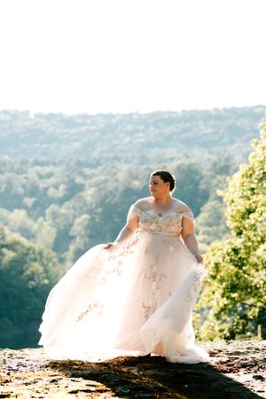 A bride poses for her whimsical elopement bridal portraits at Rocky Top Falls in Fairfield Bay, Arkansas.