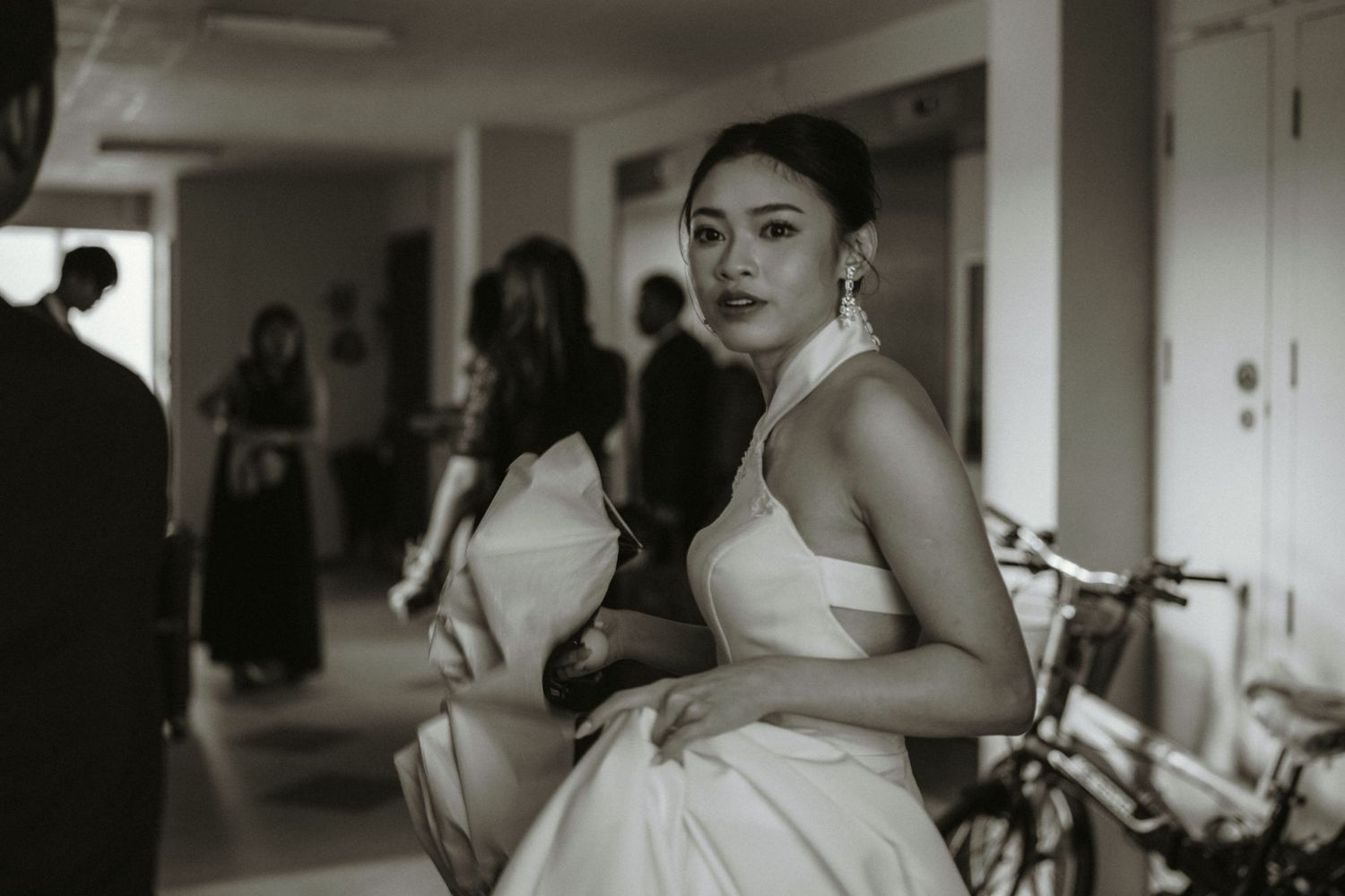 A black and white portrait of someone in formal attire preparing for a special occasion.