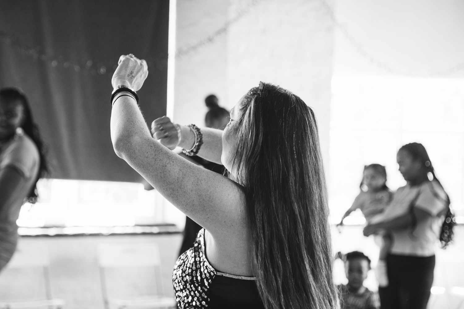 Black and white photo of dance or exercise class in studio setting.