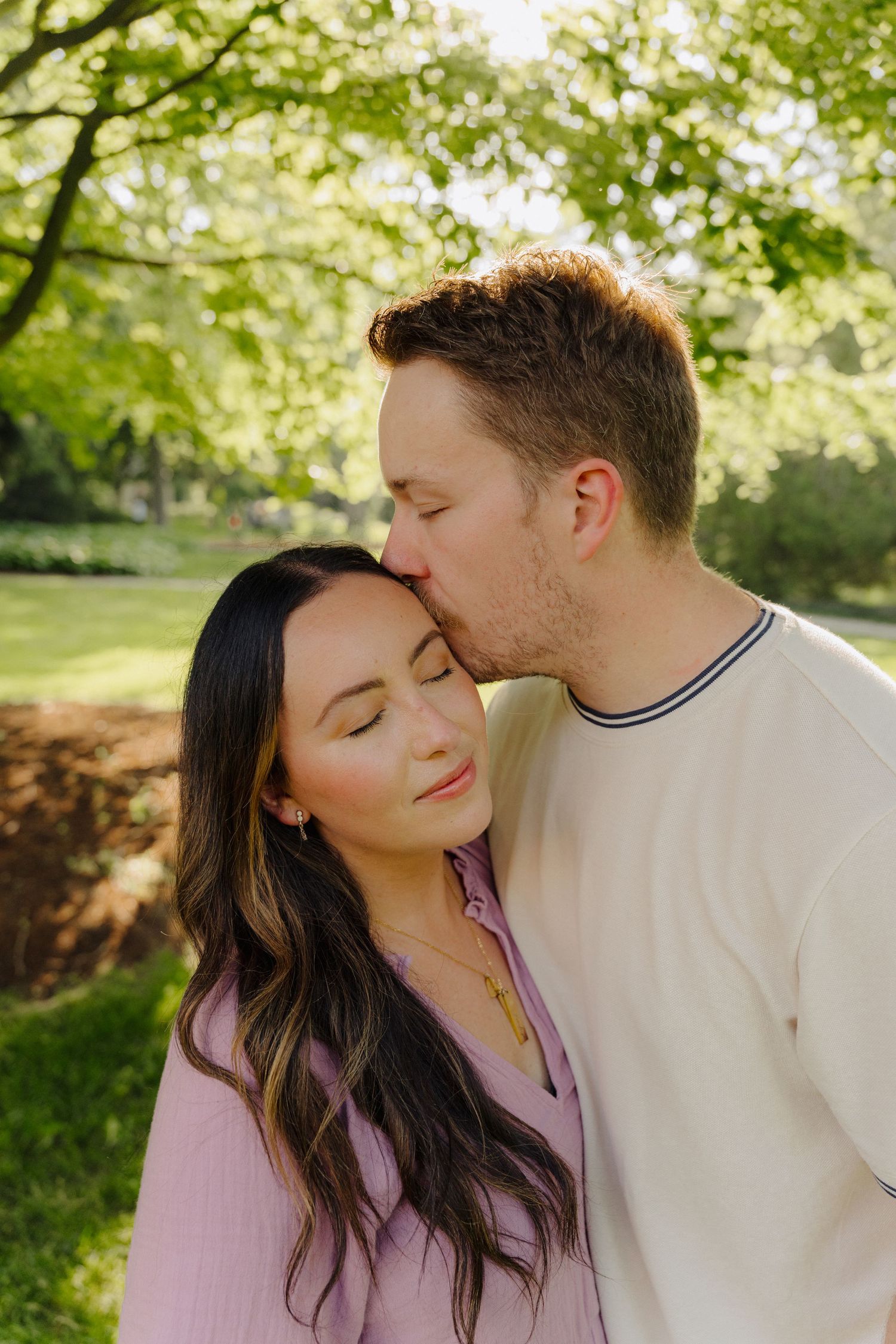 A cozy couple portrait against neutral background wearing casual sweaters.