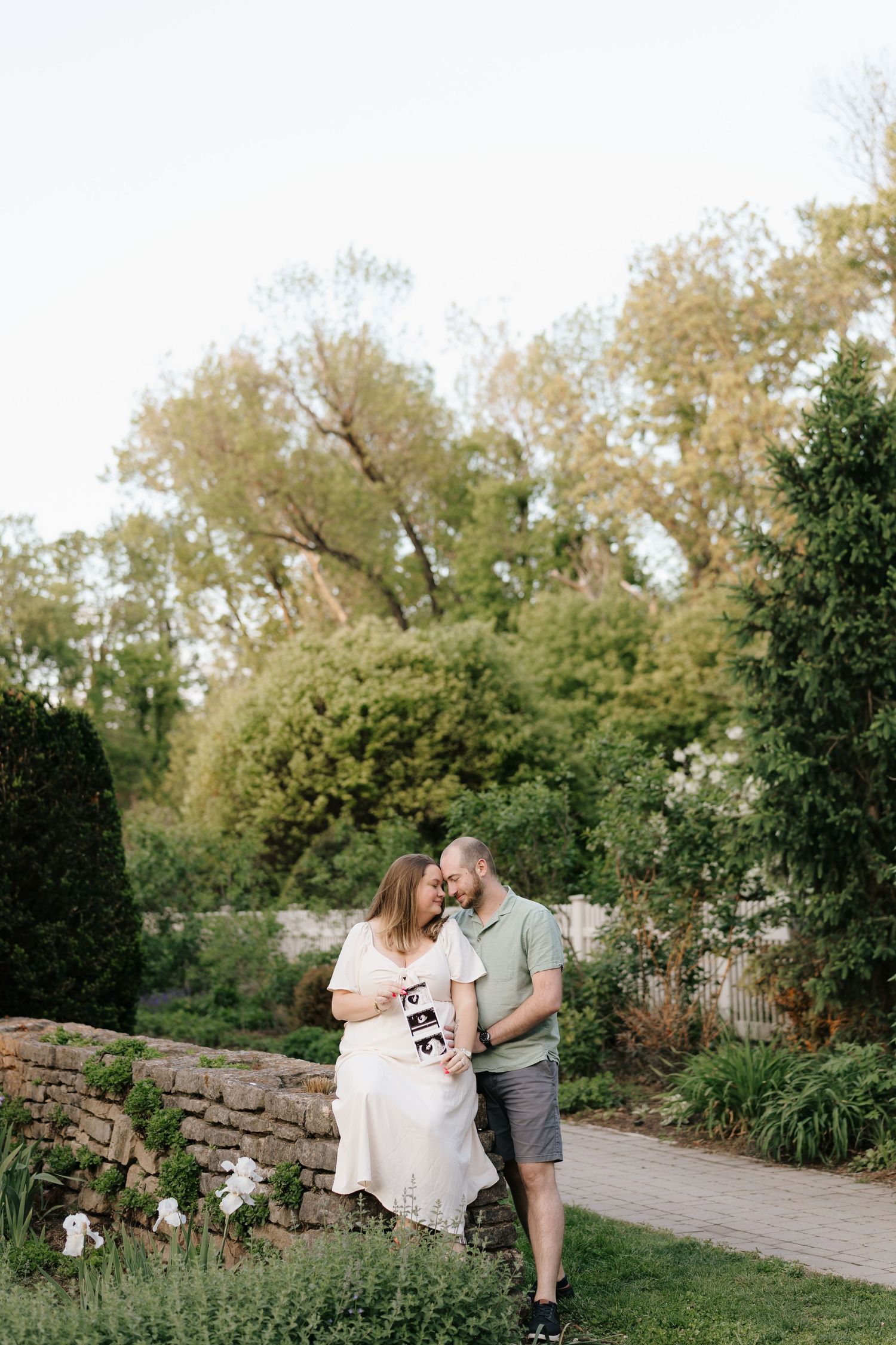A couple in wedding attire embrace outside a historic building with gold doors and a bottle of champagne nearby.