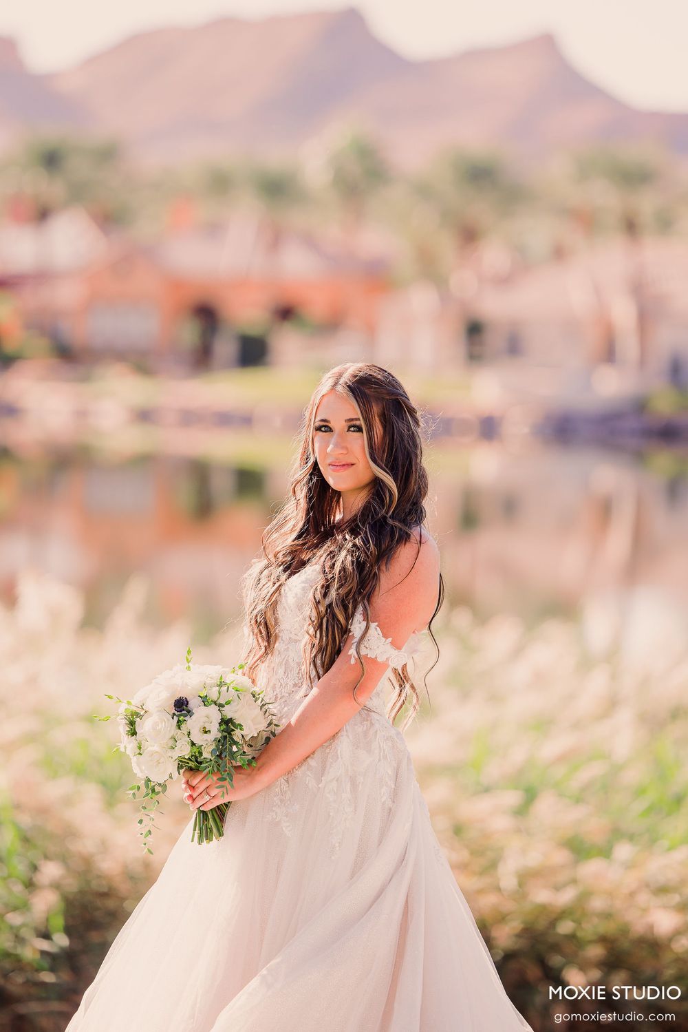 A series of dreamy outdoor bridal portraits in a desert landscape with soft lighting and white floral details.