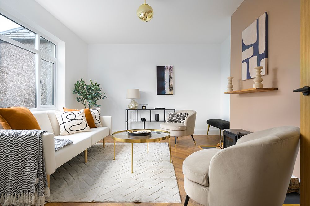 A modern minimalist apartment interior with light wood flooring and white walls showcases sleek furnishings and natural light.