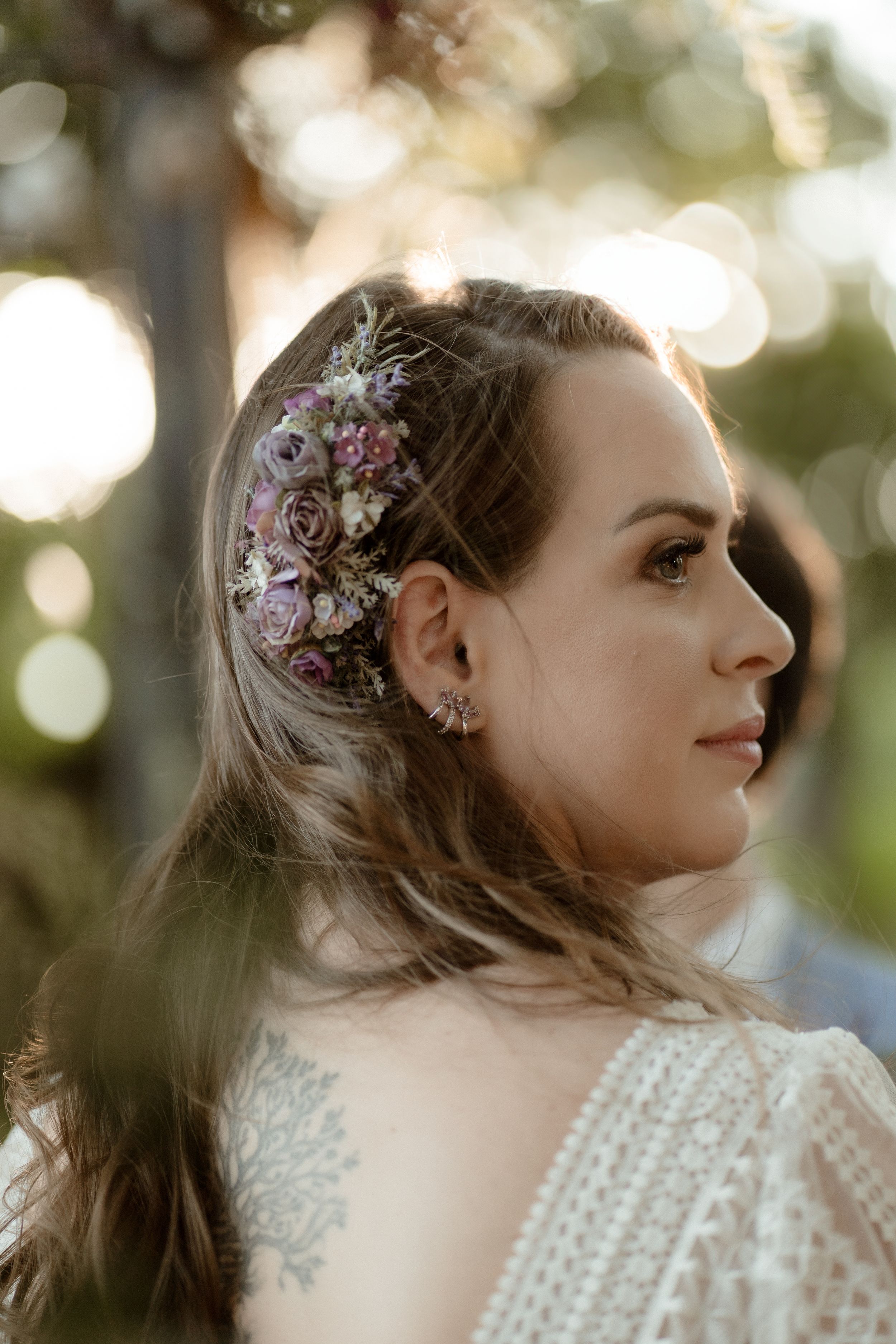 A side profile view showcases delicate floral hair accessories and lace dress details.