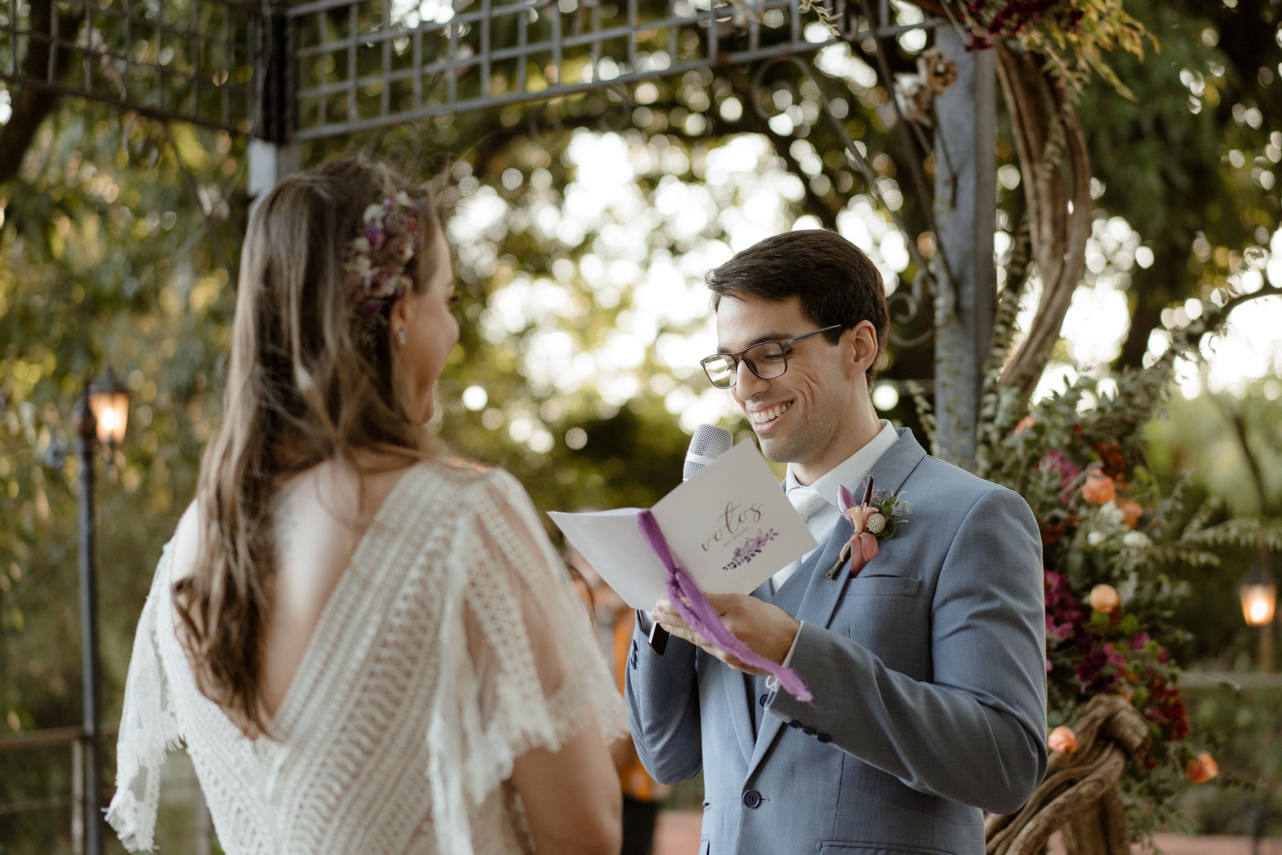 A couple shares an intimate moment while exchanging vows during an outdoor wedding ceremony.