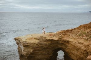 Panoramic view of rugged coastal cliffs against a cloudy ocean backdrop.