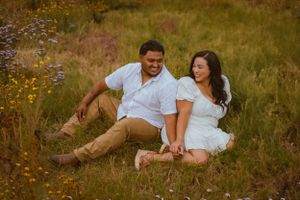 Couple enjoying intimate moments together in a field of yellow and purple wildflowers.