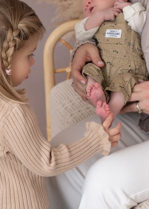 A close up shot of big sis touching baby siblings toes during a candid newborn session moment. Wrightstown NJ Newborn Photographer