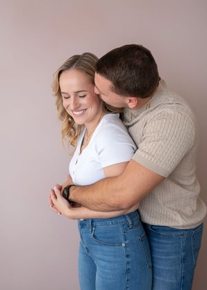 A couple locked in a embrace with husband hugging wife from behind in a loving moment. Wrightstown NJ Family Photographer
