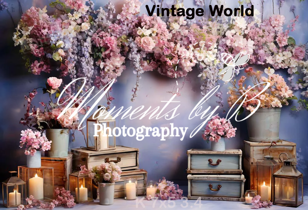 Vintage photography setup with antique suitcases, candles, and pink floral arrangements in a dreamy romantic display.