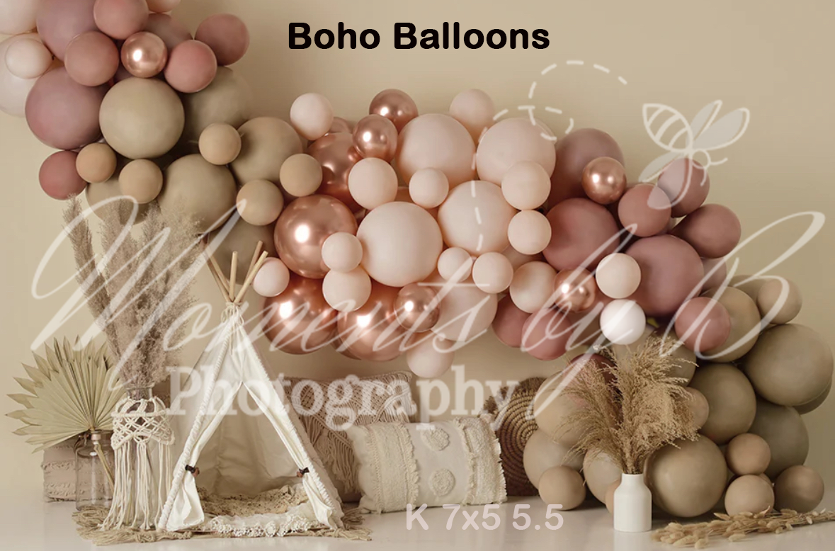 Modern balloon arch installation in neutral tones of pink and beige with pampas grass accents.
