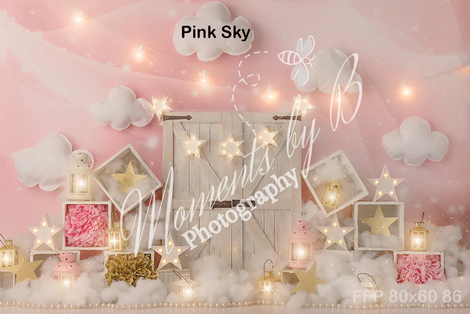 Dreamy pink backdrop with floating clouds, string lights, and decorative white wooden houses.