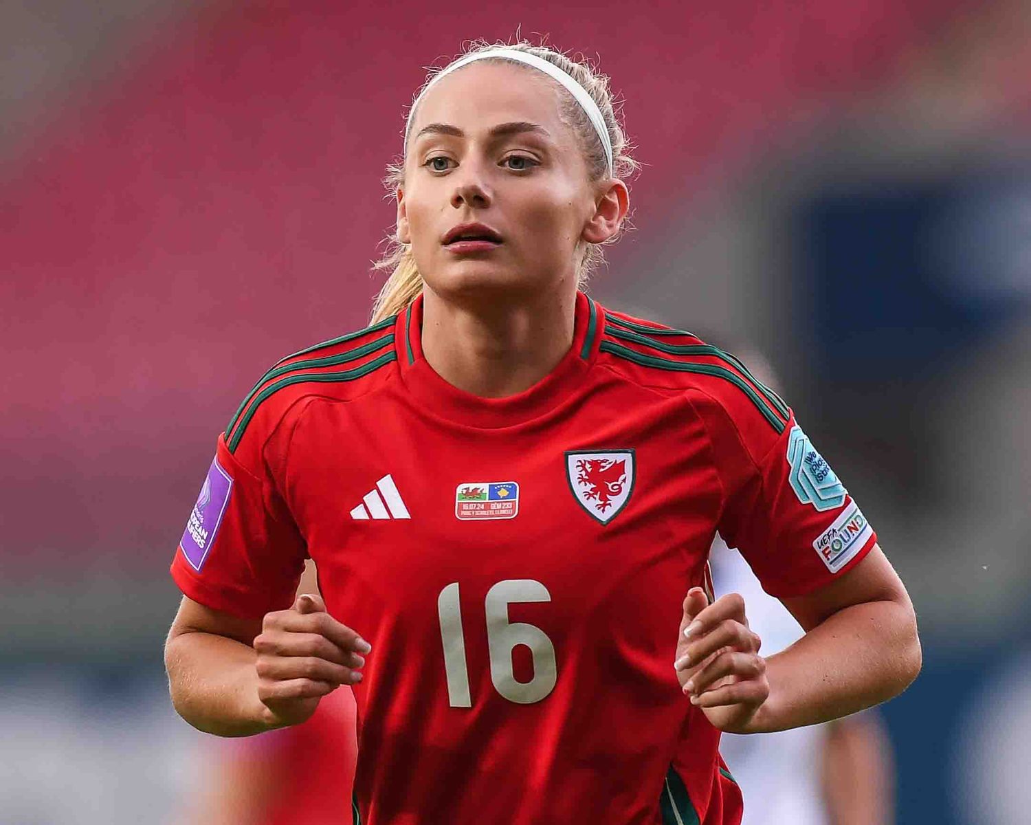 Soccer player in red uniform with number 16 during match.