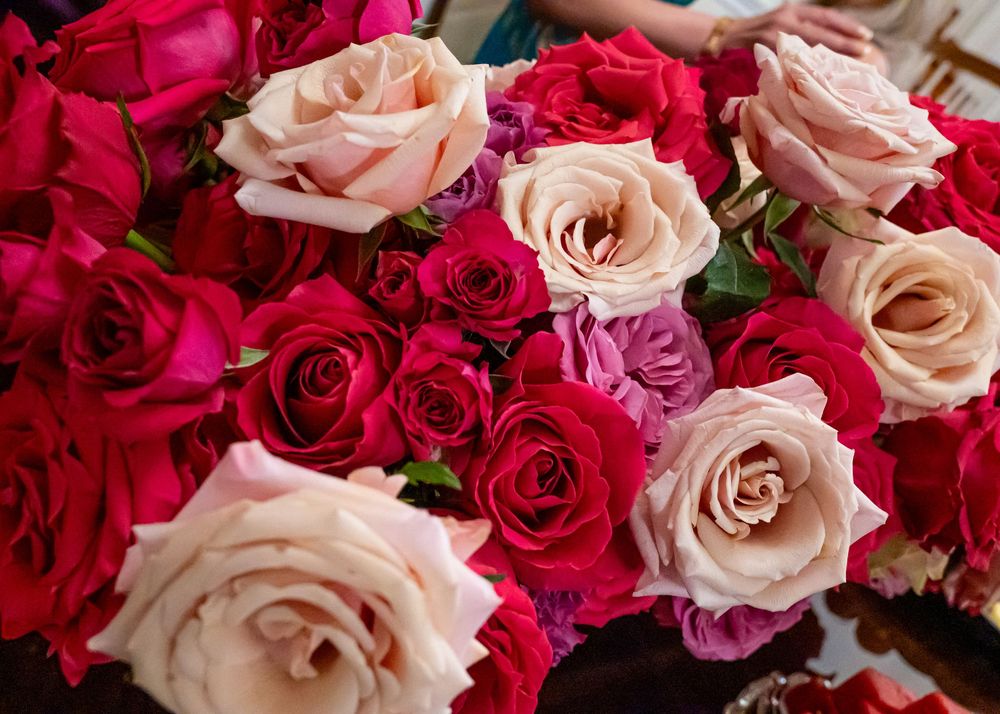 Vibrant arrangement of red, pink, and cream roses displayed at a special celebration event.