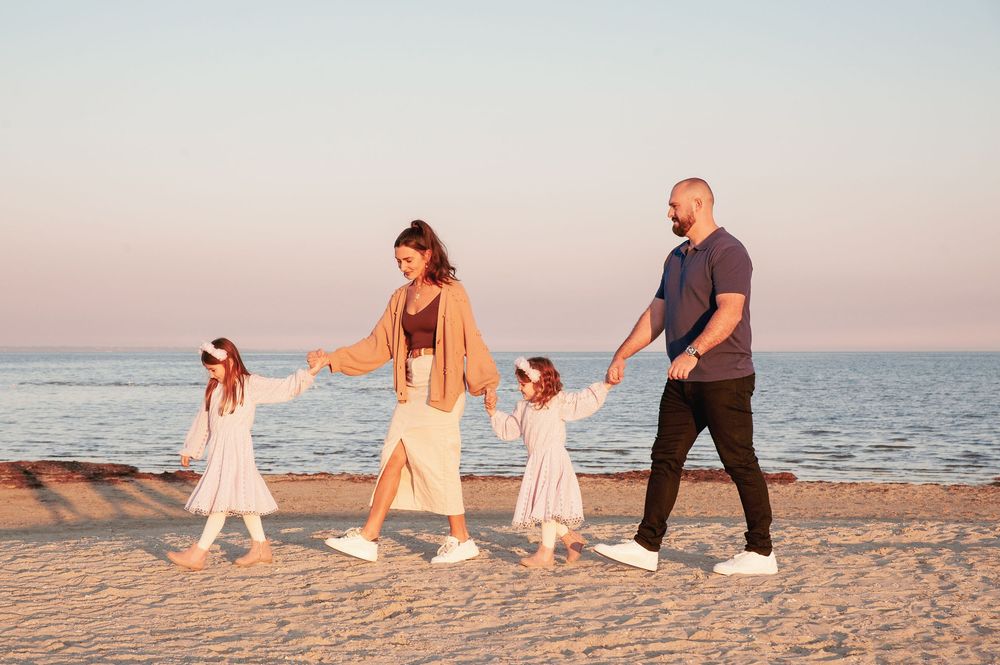 Family walking together on beach during sunset wearing light colored clothing.
Altona Family Photographer Melbourne