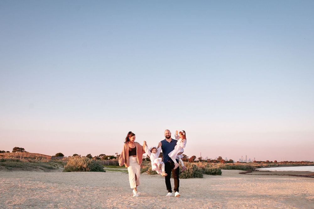 A family walks and plays together along the shoreline during sunset. 
Altona Family Photographer Melbourne