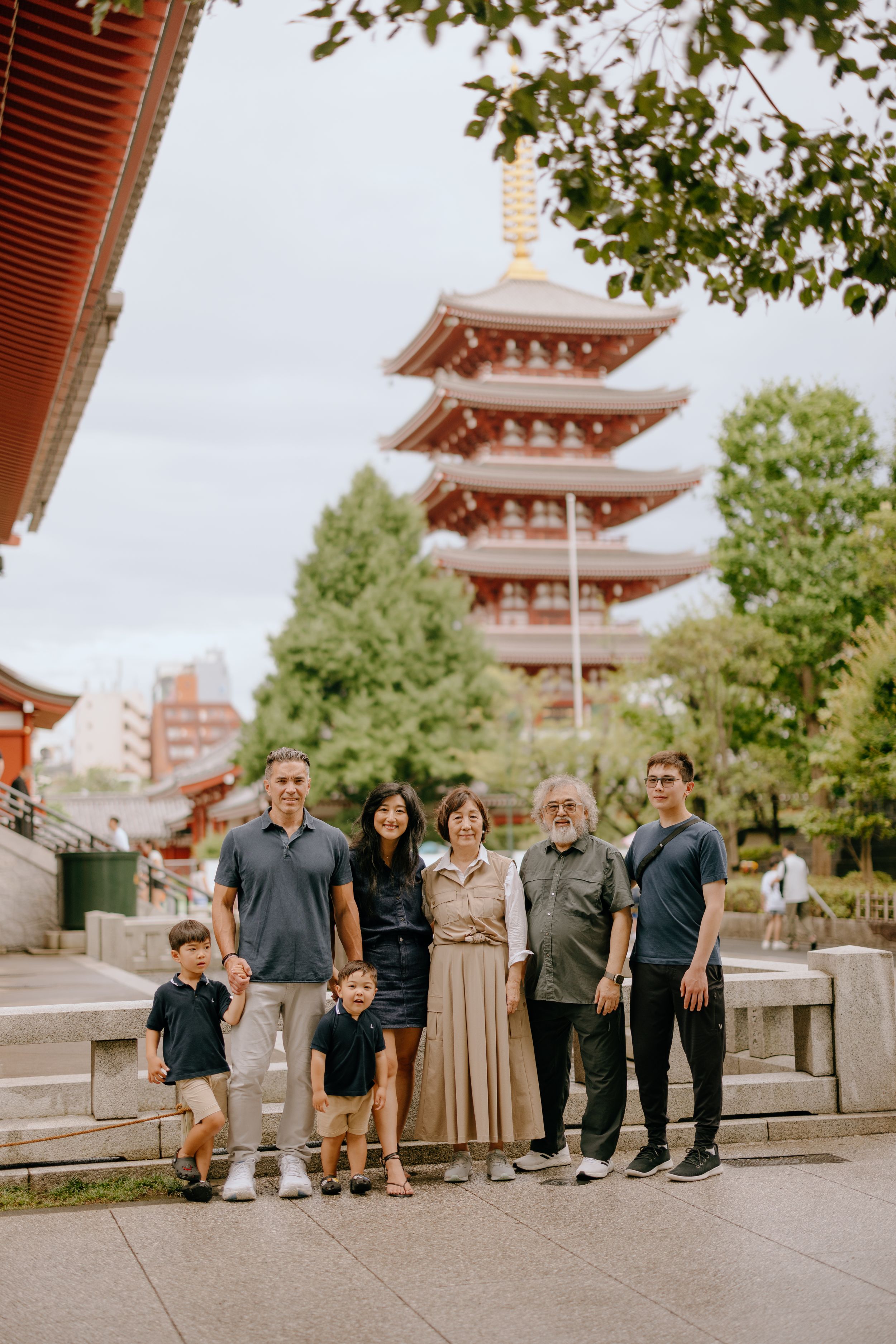 Group photo in front of a traditional five-story pagoda at a Japanese temple.