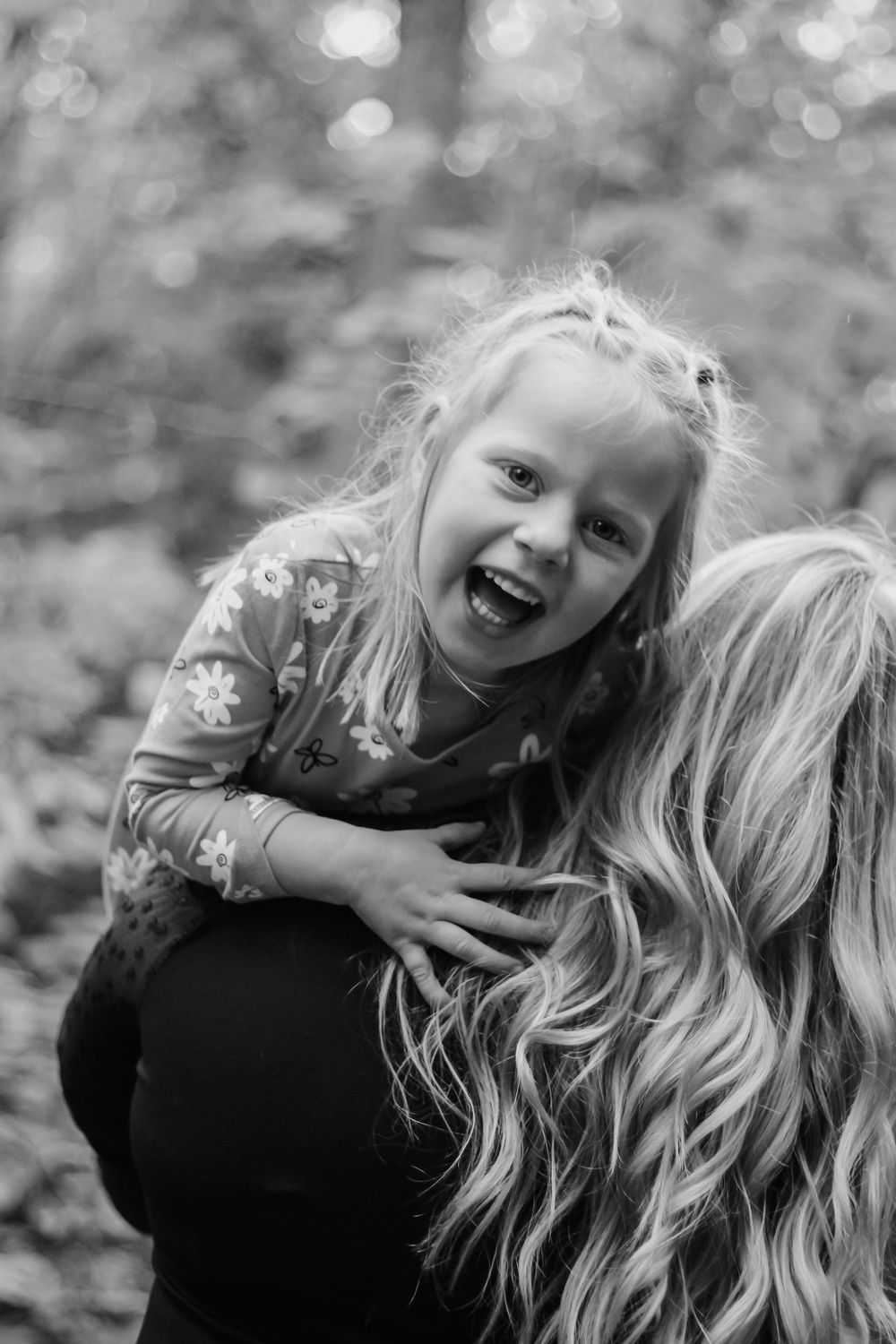 Black and white portrait capturing joyful laughter between parent and child.