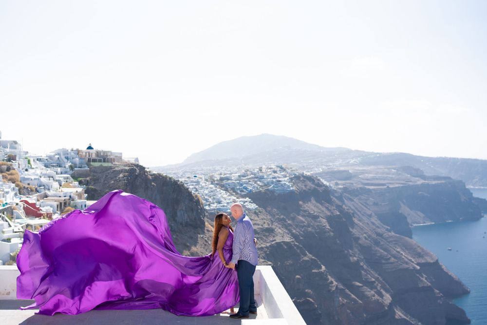 Flowing purple fabric catches wind against Santorini's dramatic caldera views.