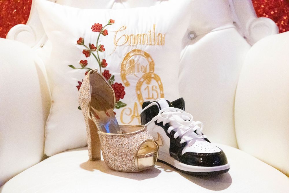 Contrasting footwear display showing a sparkly gold heel and casual sneaker on white chair with custom design.