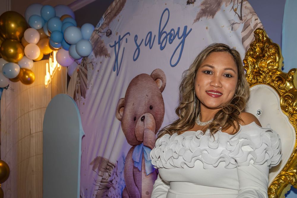 Baby shower celebration setup with blue balloons and decorative backdrop.