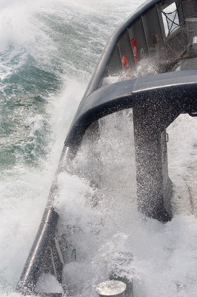 Dramatic view of waves crashing against ship's window during rough seas.