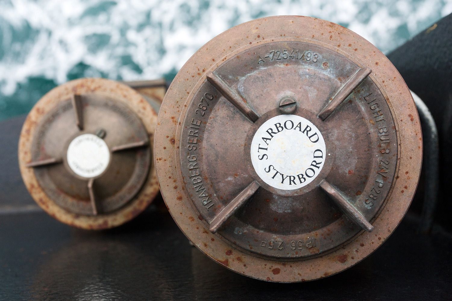 Close-up view of weathered nautical compass dials on a ship.