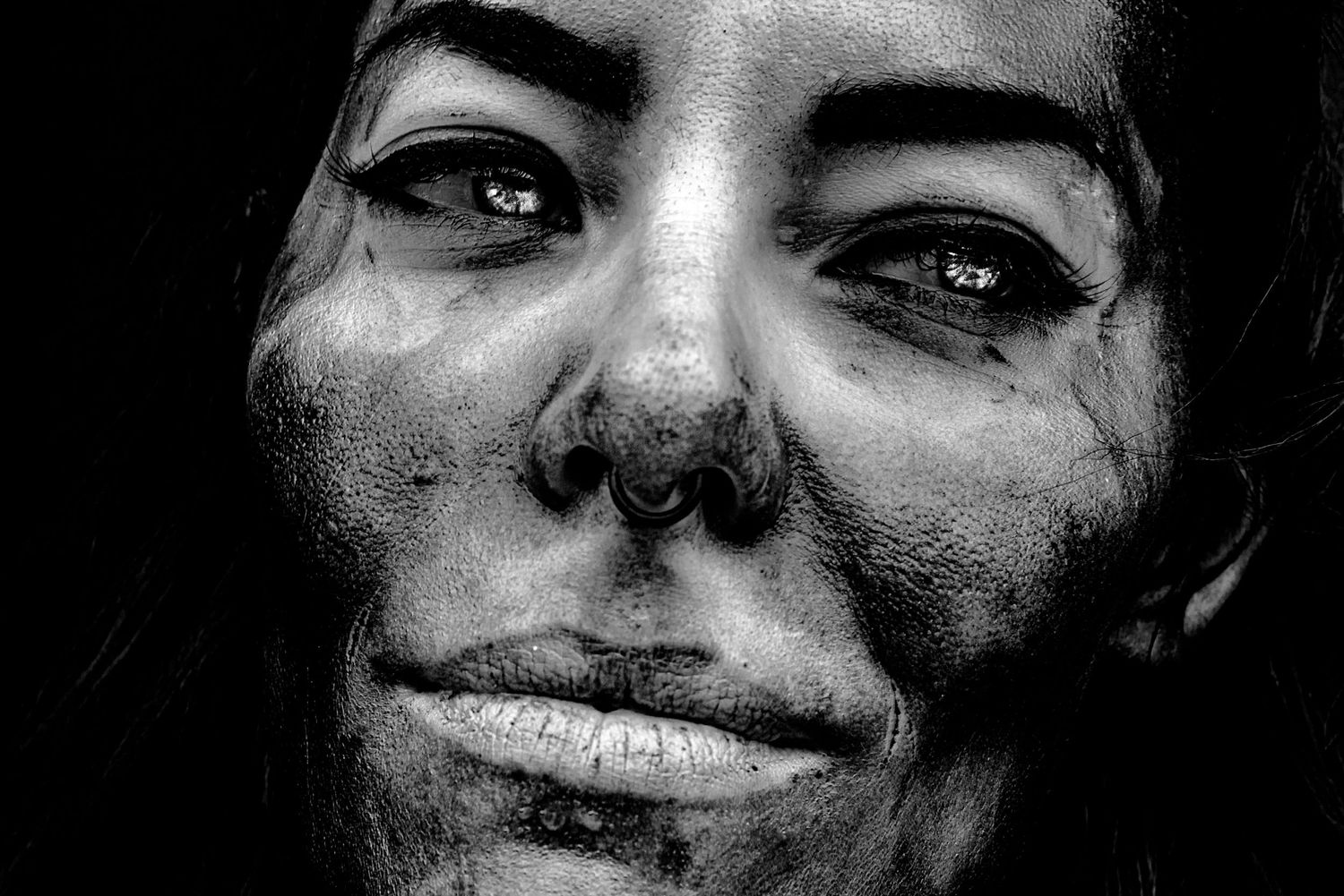 Black and white close-up portrait showing an expressive smile.