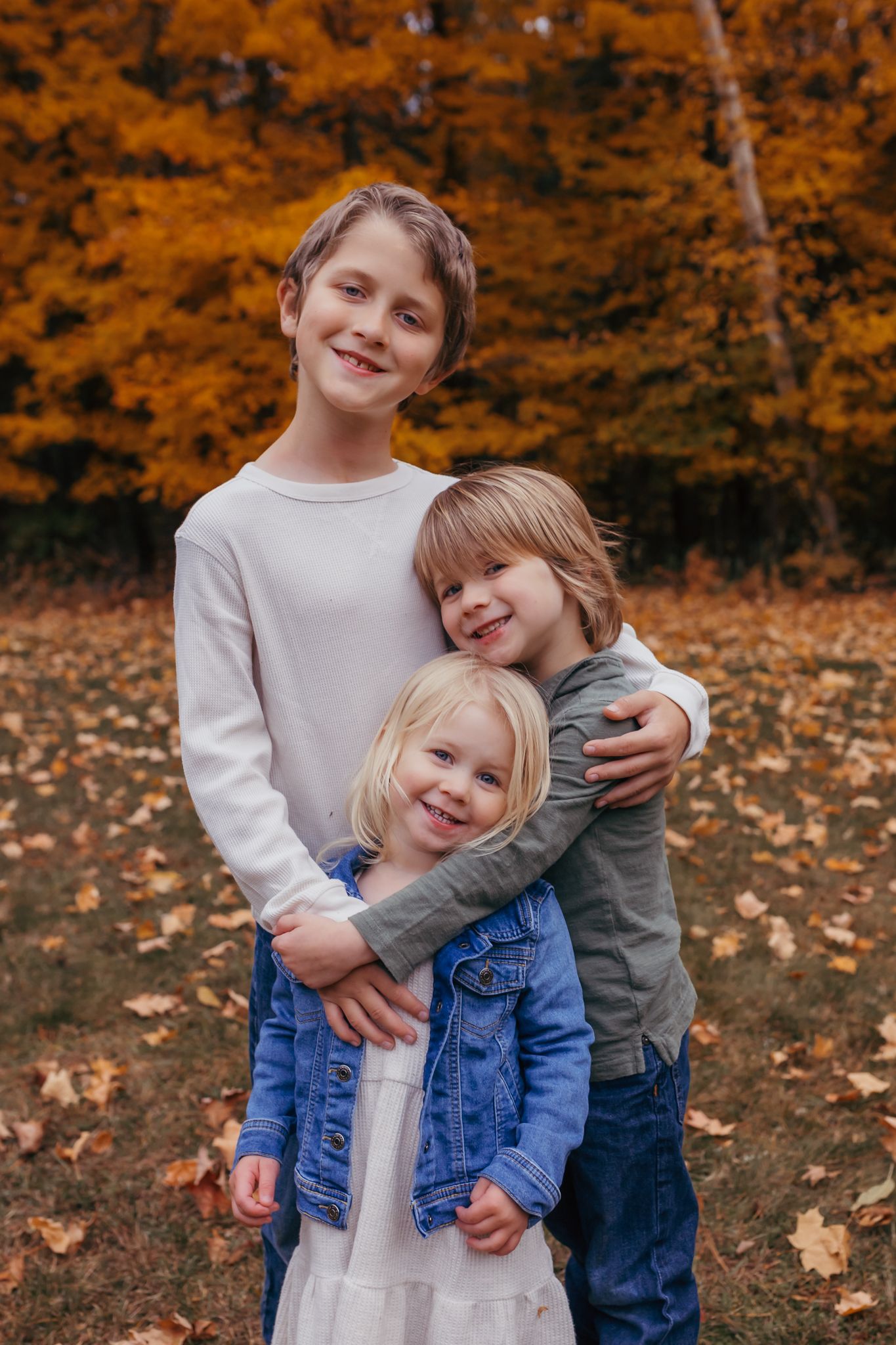 Three kids smiling for family photos in Rhinelander.