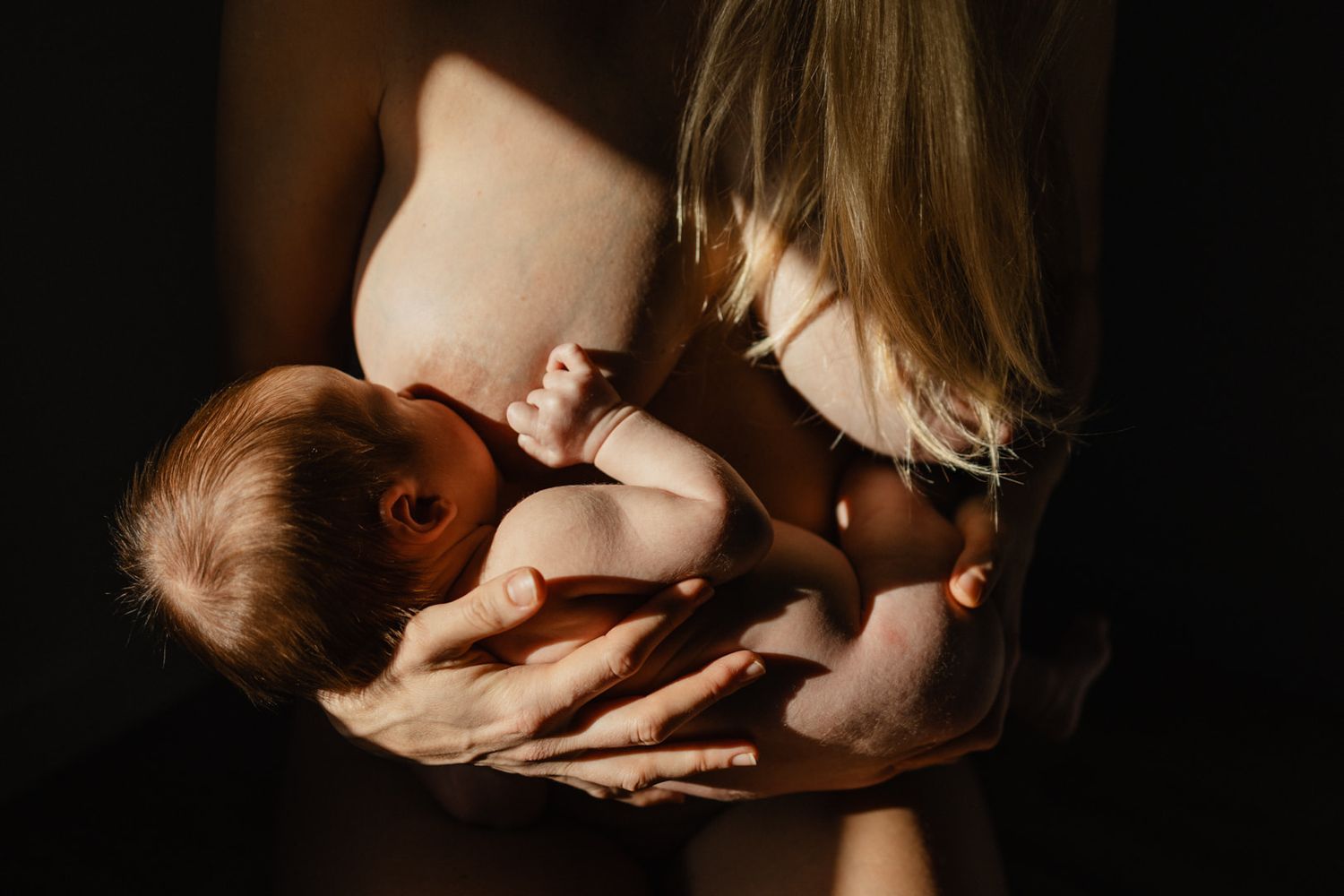 Photo d'allaitement en peau à peau realisee pendant un shooting avec Nathalie Klein photographe famille et maternite lifestyle