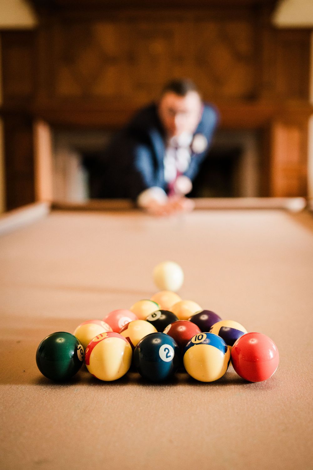 Image of a groom playing pool before the wedding at Dalston Hall, Cumbria