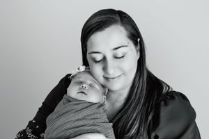 Intimate black and white portrait of parent and newborn sharing quiet moment.