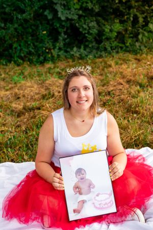 Sweet sixteen photo shoot featuring white top, red tulle skirt and childhood photo display.