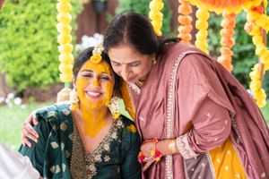 Traditional Indian ceremony with yellow and orange hanging floral decorations.