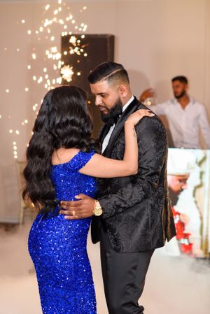 A couple shares an intimate dance under twinkling lights at an elegant reception.