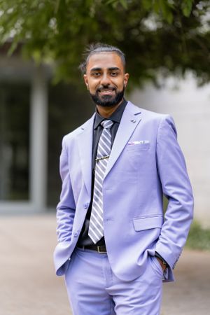 Professional portraits showcase a dapper lavender suit with striped tie against white building.