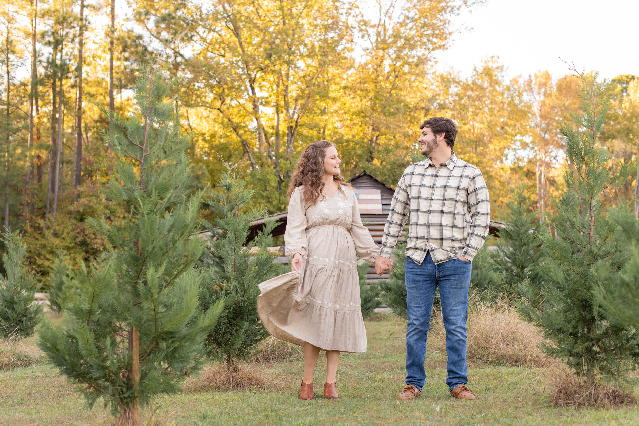 Candid couple dancing and interacting in front of barn at Lakewood Tree Farm in Chapin, SC.
