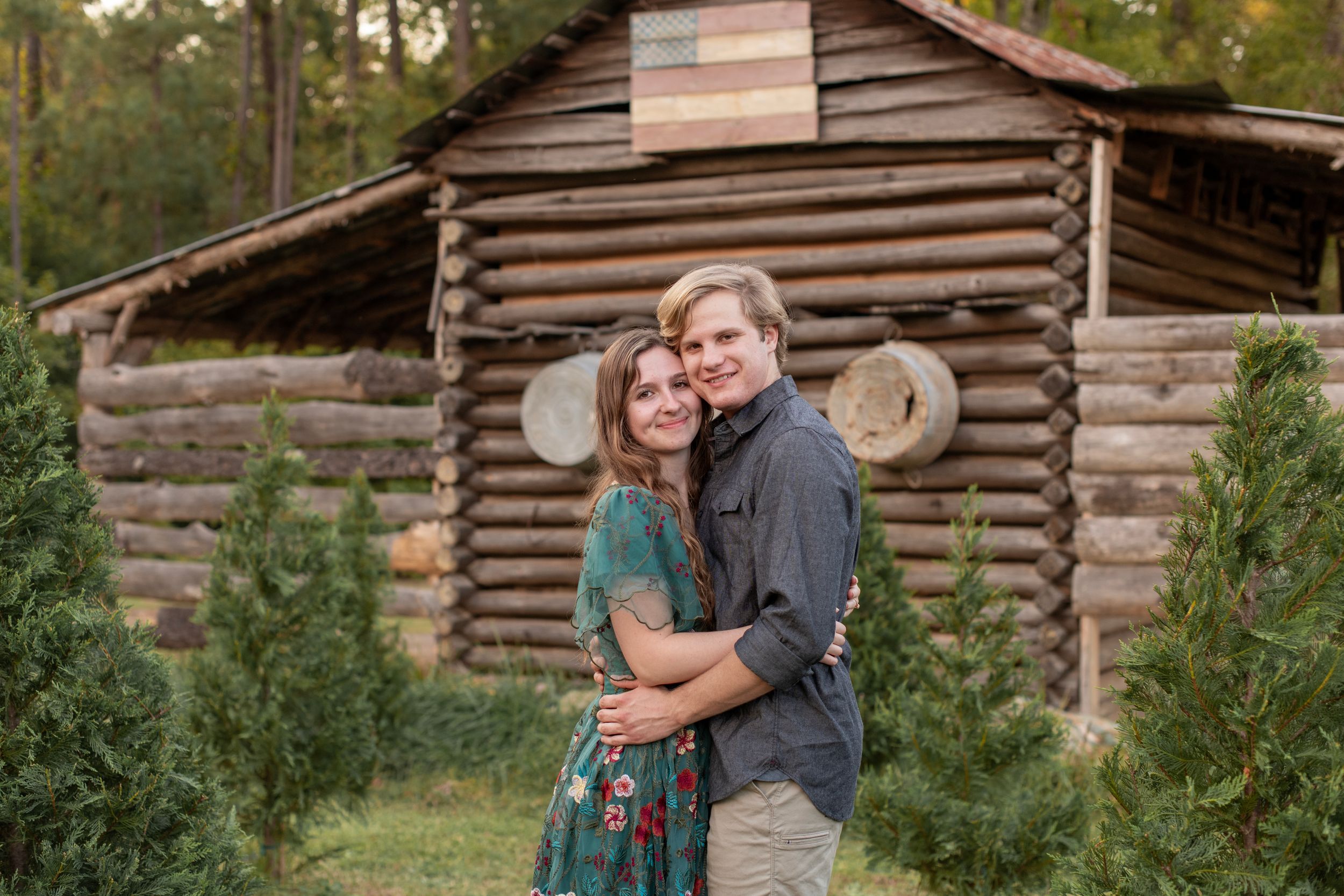 Couple hugs in front of old barn at Lakewood Tree Farm in Chapin, SC.