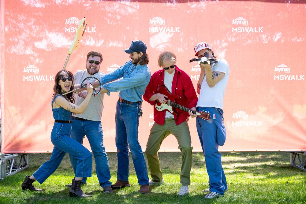 A sequence of four action shots showing dancers performing energetic swing dance moves outdoors against a pink wall.