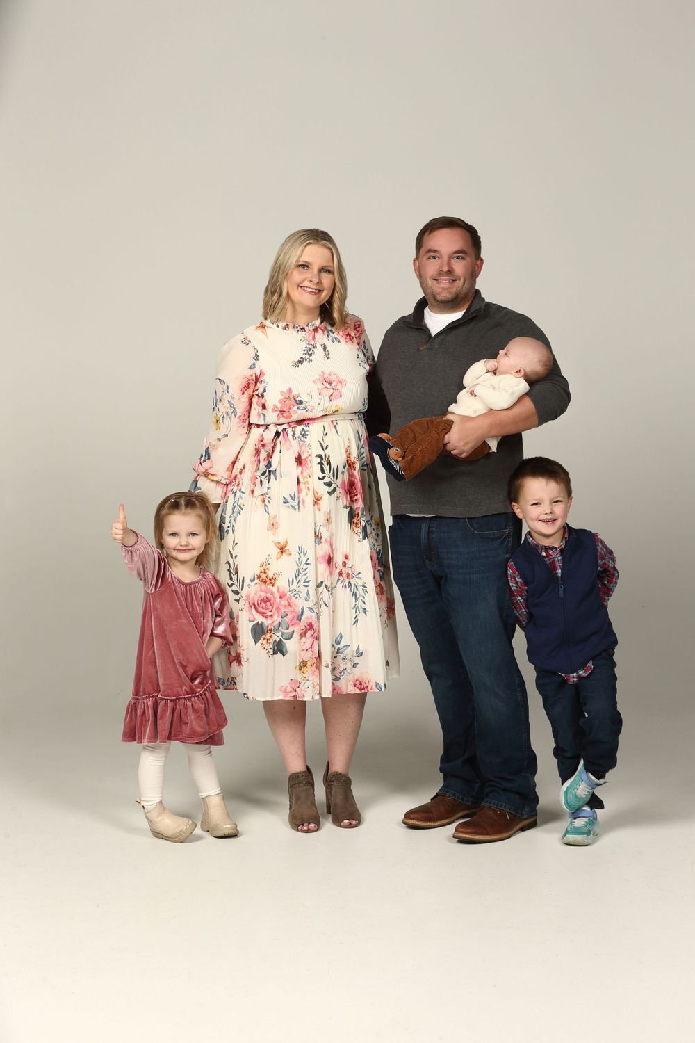 A family photo sequence showing a growing family in coordinated outfits against a light studio backdrop.