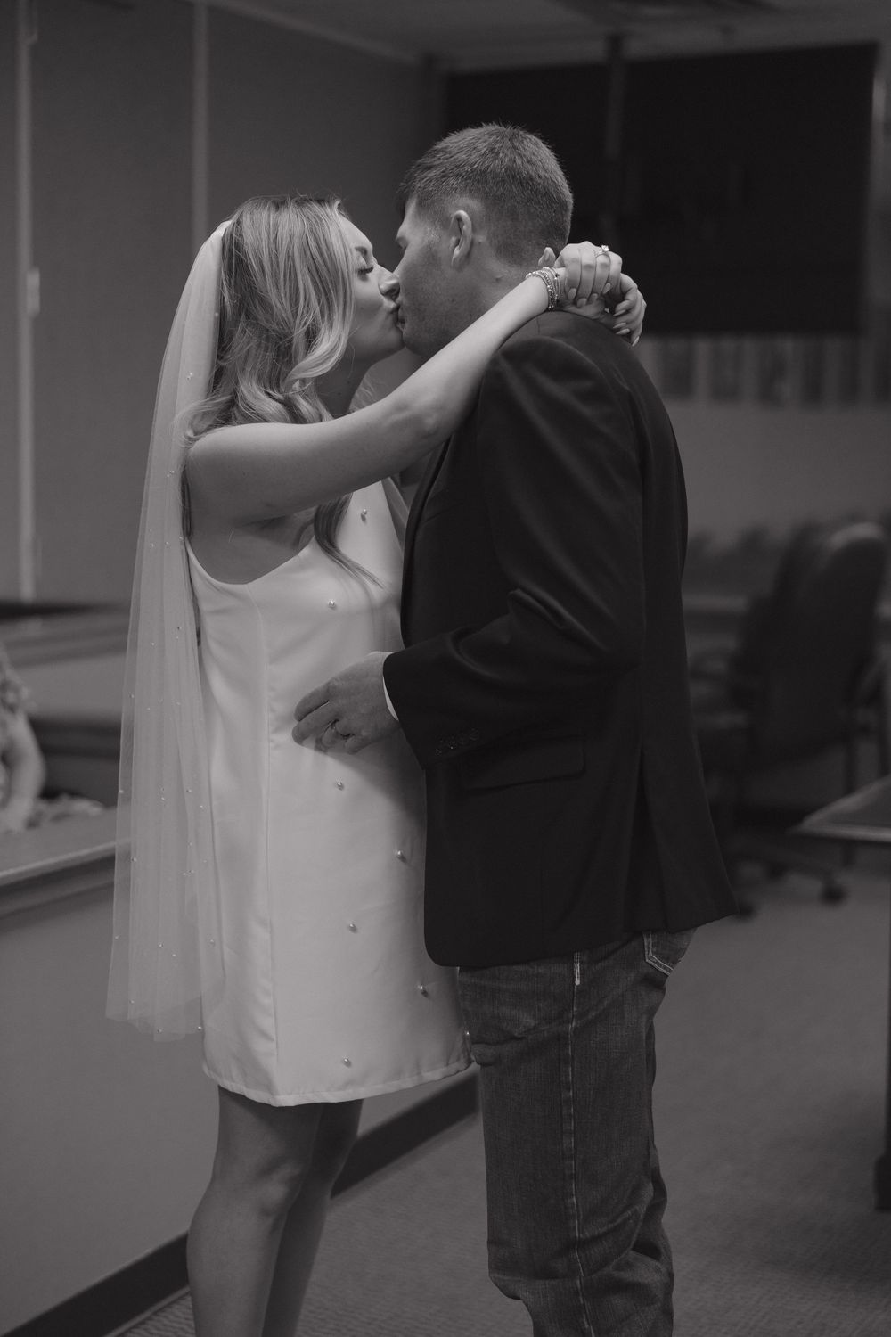 A couple in black and white share an intimate dance together in what appears to be an empty venue.