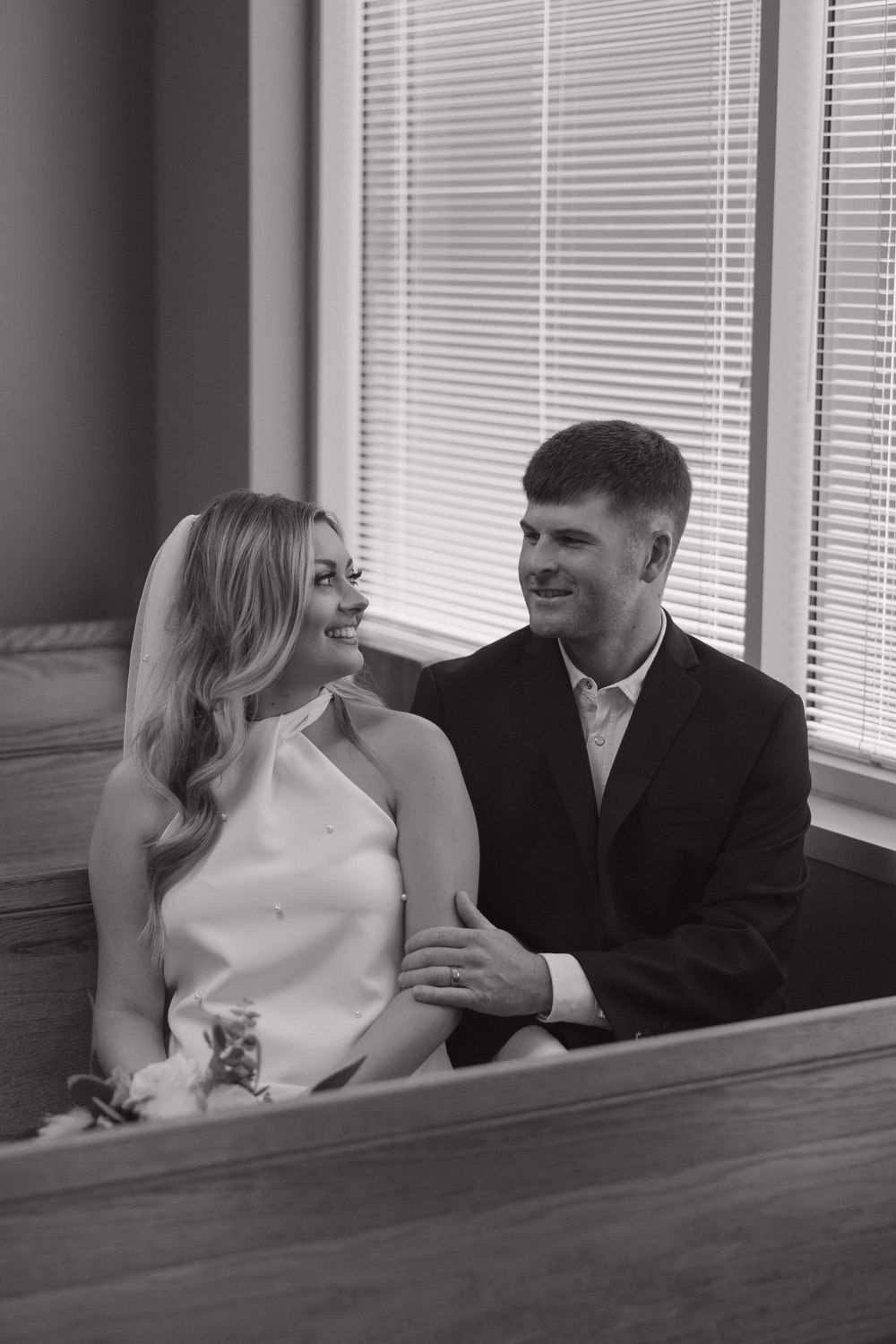 A black and white photo sequence shows a couple sharing intimate moments while sitting together on a bench.